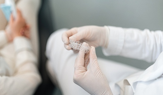 Dentist holding clear aligner