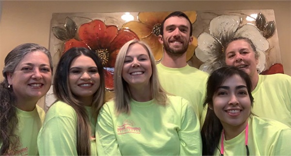 Collinsville dentists and team members wearing yellow shirts in dental office
