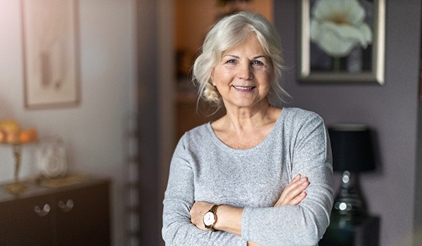 Older woman smiling after learning about the cost of dental implants in Collinsville