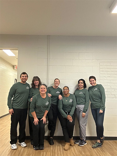 Collinsville dental team members posing in dental office wearing yellow shirts