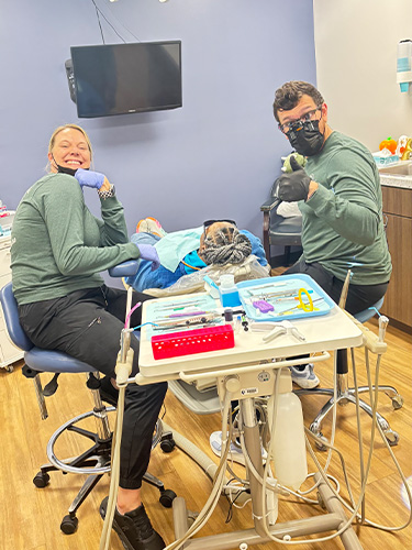 Collinsville dentists and team members wearing yellow shirts in dental office