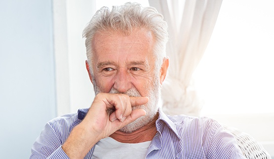 Senior man covering his mouth with his hand