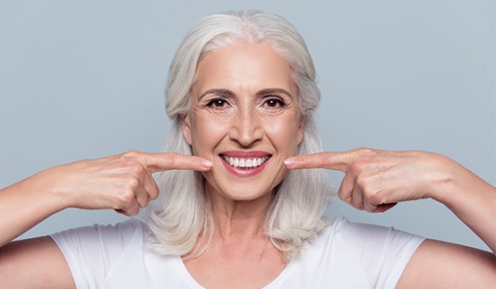 Senior woman pointing to her smile