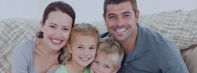 Smiling family of four sitting on a couch