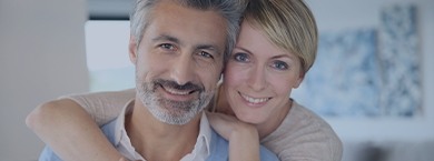 Smiling older man and woman in their living room