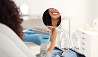 Dental patient admiring her smile in mirror
