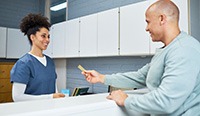 Person using card to pay for treatment in dental office