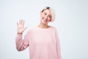 Smiling woman waves at her Collinsville dentist