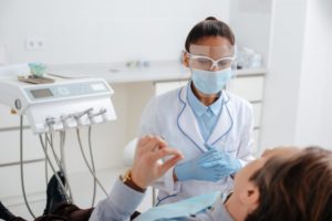 Patient talking to their Collinsville dentist during appointment in COVID-19