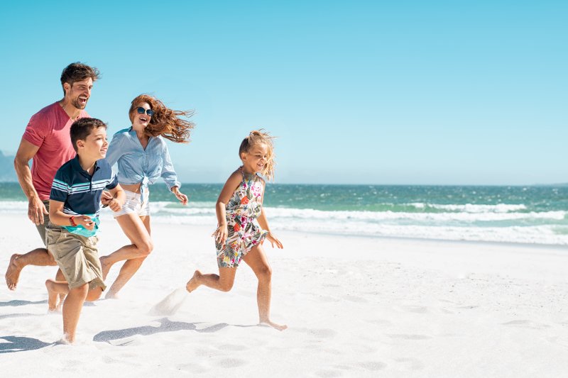 family running on beach during summer vacation