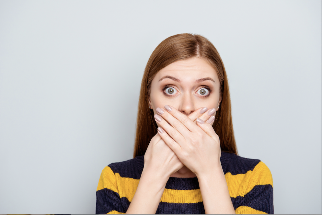 woman hiding bad breath with hands 