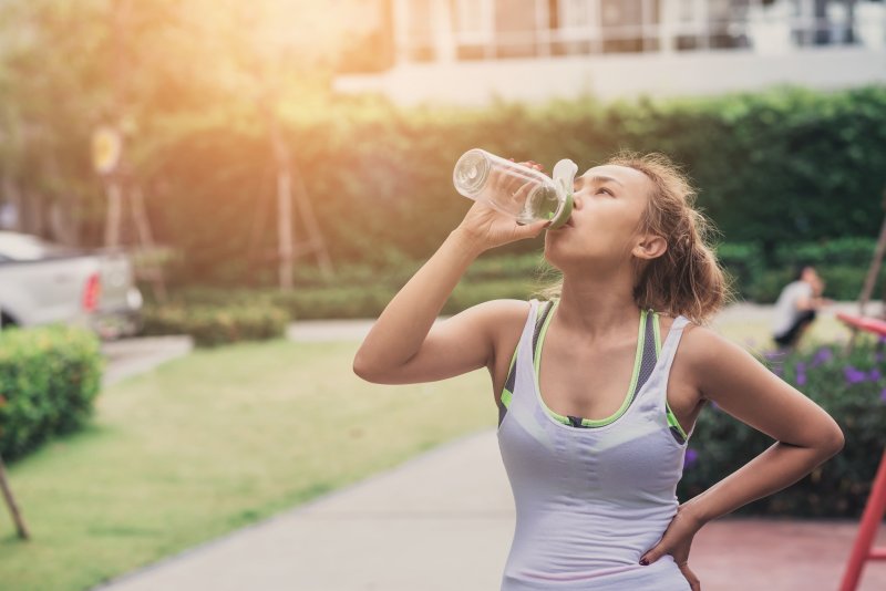 young woman drinking water during summer