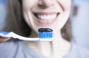 Activated charcoal toothpaste on a toothbrush.