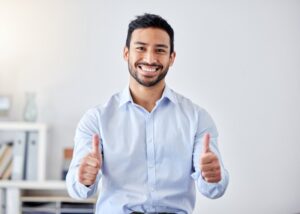 Man smiling and holding two thumbs up